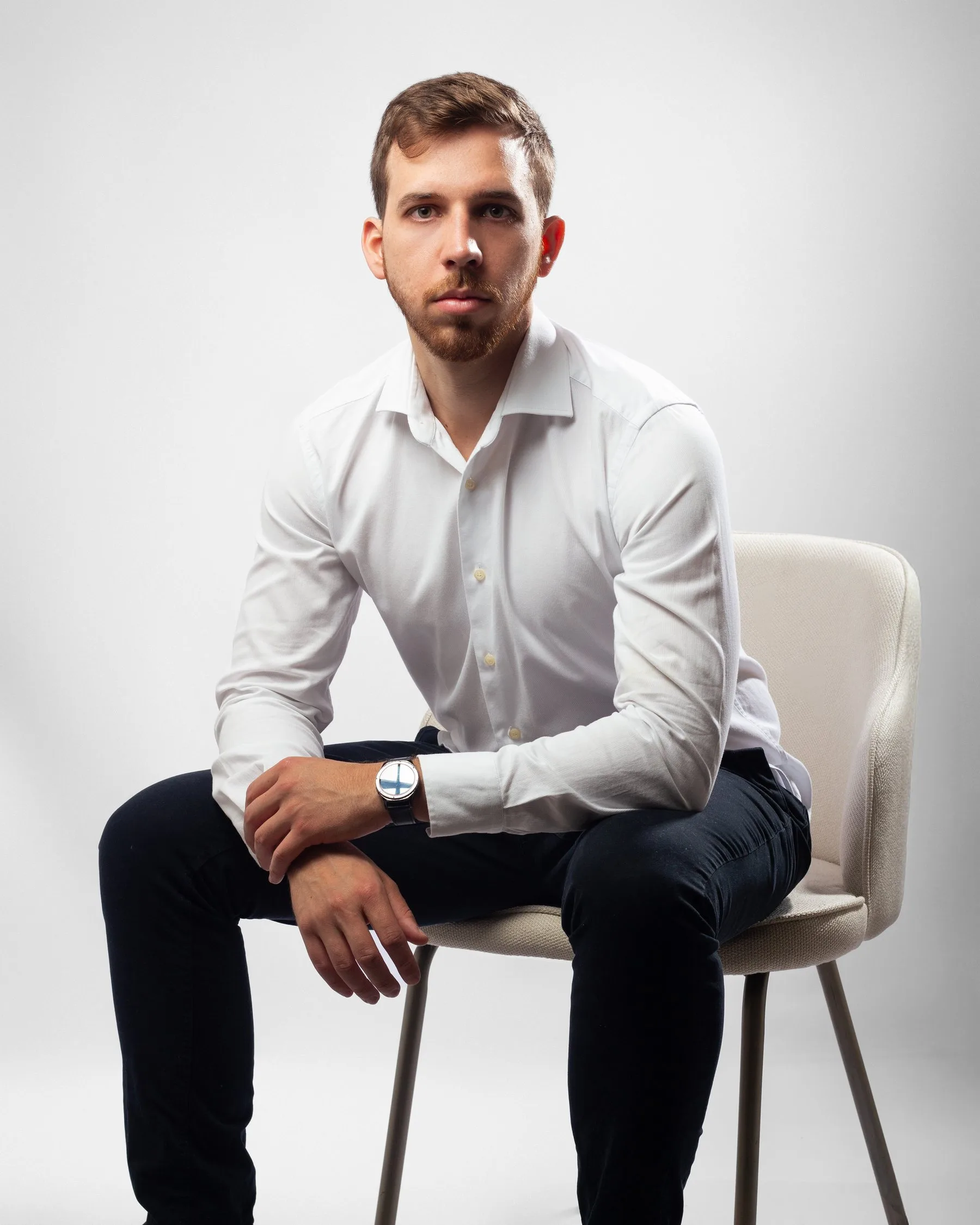 Dr. João Lucas Rosa sentado, de camisa branca, olhando para a câmera